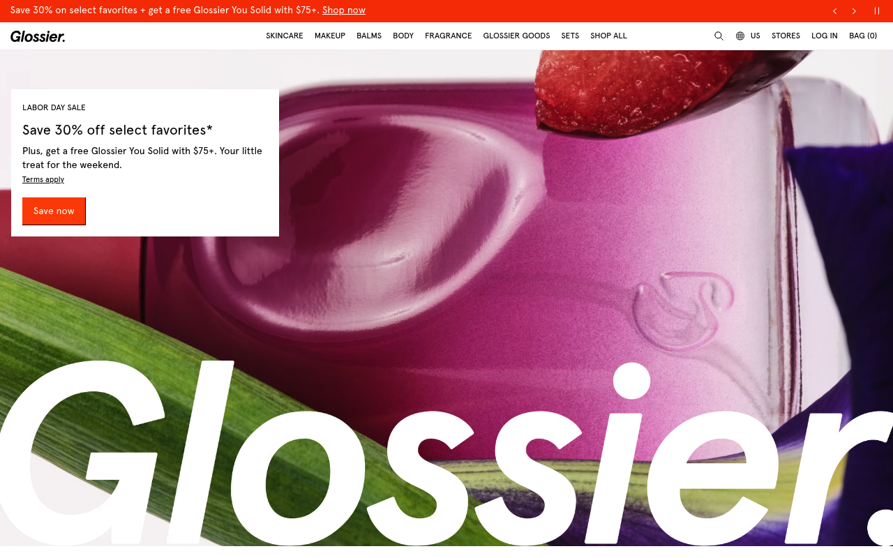 Glossier homepage running oversized brand typography straight over the product photography